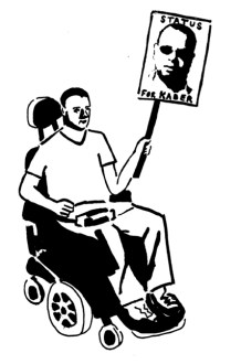 Man sitting in an electric wheelchair holding a placard with a picture of Kader that says 